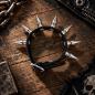 Preview: Punk-Ledermanschette mit einer Reihe Spikes auf einer markanten Holzoberfläche
